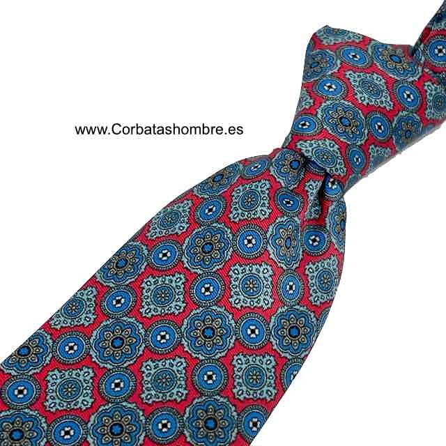 CORBATA DE SEDA CON ROSETONES GEOMÉTRICOS AZULES SOBRE FONDO ROJO 